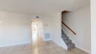 Located at 311 Gulfstream Rd in Dania Beach, Florida, this two-story, three-bedroom, three-bathroom home offers a thoughtfully laid-out floor plan spread across two floors. The main level features a bright living room, a dedicated dining room, and a well-appointed kitchen complete with white cabinetry, dark granite-style countertops, a rich tile backsplash, stainless steel appliances including a range, dishwasher, and refrigerator, and a skylight that floods the space with natural light. Light-toned ceramic tile flooring runs throughout the main level, creating a clean and cohesive look. A carpeted staircase with a warm wood handrail connects the two floors. The upper level houses all three bedrooms, each featuring wood-look plank flooring and generous closet space — with six closets total throughout the home. The primary bedroom is spacious and includes its own dedicated bathroom. The additional bathrooms are finished with neutral beige tile, one featuring a tub-shower combination and another a walk-in shower. Outdoor spaces include both a patio and a balcony, ideal for enjoying the South Florida climate. The home's clean white walls, abundant natural light, and functional layout make it a comfortable and versatile residence.