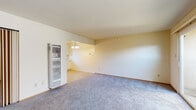 Located at 6530 Schmidt Ln in El Cerrito, California, this single-floor residence offers a practical and comfortable layout throughout. The generously sized living room features soft blue-grey carpeting and neutral walls, opening directly into the dining area, which is accented by a classic chandelier. A wall-mounted heating unit provides efficient climate control in the living space. Sliding glass doors in the living area lead to an outdoor patio, allowing natural light to fill the room and providing easy access to the exterior.

The kitchen is equipped with ample white cabinetry featuring chrome hardware, a coil-top electric range, and tile flooring, offering a clean and functional cooking space. The adjacent dining area connects seamlessly to the kitchen, making the layout ideal for everyday living.

The bedrooms are carpeted and feature large windows that bring in natural light and views of the surrounding neighborhood. Each room offers generous wall space, and at least one bedroom includes a built-in closet with shelving and hanging storage.

The bathroom is well-appointed with tile flooring, a granite-topped vanity, a combined tub and shower enclosed by frosted sliding glass doors, and a window that provides natural ventilation. Overall, the space presents a clean, move-in ready environment with a straightforward and functional design.