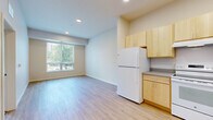 Located at 560 Humboldt Ave N in Minneapolis, MN, this efficiently designed single-floor unit offers a clean, modern aesthetic throughout. The open-concept living and kitchen area is anchored by light hardwood-style flooring and recessed lighting, creating a bright and welcoming atmosphere. A large window with vertical blinds floods the living space with natural light and frames views of the surrounding greenery and neighborhood streetscape.

The kitchen is outfitted with light maple cabinetry, ample upper and lower cabinet storage, a full-size refrigerator, and an electric range, all set against neutral countertops. The layout allows for a seamless flow between cooking and living areas.

The bedroom features soft carpeting, a generous double-door closet, and a window that brings in additional natural light. The full bathroom includes a single-sink vanity with maple cabinetry, a soaking tub with shower, and accessibility grab bars installed throughout. Multiple closets and a dedicated utility room provide excellent storage and organizational flexibility.

The unit maintains a consistent neutral color palette of whites and warm beiges, contributing to a calm and functional living environment. Recessed lighting and a programmable thermostat add to the unit's modern, practical conveniences.