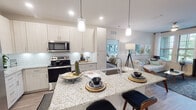 This single-floor residence features a thoughtfully designed open-concept layout that seamlessly connects the kitchen, dining, and living areas. The kitchen serves as a central hub, showcasing granite countertops, a large island with bar seating, white shaker-style cabinetry, stainless steel appliances including a French door refrigerator and electric range, and a white subway tile backsplash. Pendant lighting above the island adds a polished finishing touch.

The living area benefits from multiple large windows fitted with plantation-style blinds, allowing ample natural light while maintaining privacy. Wood-style flooring flows throughout the main living spaces, contributing to a cohesive, modern aesthetic.

The space includes two bedrooms, each featuring large windows, neutral tones, and wood-style flooring. Both rooms offer comfortable proportions suitable for full-sized furniture arrangements.

Two full bathrooms mirror each other in design, each featuring granite-topped vanities with under-mount sinks, wood-toned cabinetry, subway tile tub-shower combinations, and wood-style flooring. The overall design palette throughout the unit is light and neutral, creating a clean, contemporary ambiance.