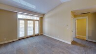 Located at 1302 Eisenhower Rd in Valparaiso, Indiana, this single-floor residence offers a thoughtfully designed layout with a warm, neutral color palette throughout. The living area is a standout, featuring soaring vaulted ceilings with a skylight that floods the space with natural light, soft carpeting underfoot, and elegant French doors that open to an outdoor view, creating a bright and airy atmosphere. A chandelier-lit dining and entry area connects seamlessly to the kitchen via an open breakfast bar, enhancing the open-concept flow of the space. The kitchen is well-equipped with rich wood cabinetry, light countertops, tile flooring, and white appliances including a stove, microwave, dishwasher, and refrigerator. A dedicated laundry area is conveniently accessible directly from the kitchen. The bedroom is comfortably sized with plush carpeting and a window that brings in natural light and outdoor views. The bathroom features a wide vanity with dual sinks, warm wood cabinetry, a large mirror, tile flooring, and generous counter space, offering both functionality and comfort. Throughout the residence, consistent warm tones and clean finishes create a cohesive and welcoming environment.