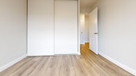 Located at 800 Exmouth St in Sarnia, Ontario, this two-bedroom, one-bathroom unit offers a clean, modern aesthetic throughout its single-floor layout. Light-toned laminate flooring flows seamlessly across all living areas, creating a bright and cohesive feel.

The open-concept kitchen and living area forms the heart of the unit. The kitchen features white shaker-style cabinetry, a stainless steel refrigerator, a built-in sink, and neutral tile backsplash. A structural column subtly defines the transition between the kitchen and the spacious living room, which is bathed in natural light through large sliding glass doors that lead to a private outdoor balcony — ideal for enjoying outdoor views.

Both bedrooms are well-proportioned and share the same warm laminate flooring. Each room is equipped with baseboard heating and windows that invite natural light. The primary bedroom includes a built-in sliding-door closet, offering practical storage. White panel doors and crisp trim throughout give the bedrooms a polished, contemporary look.

The bathroom is finished with large-format tile flooring, a full tub-shower combination with tile surround, a white vanity with storage, and classic chrome fixtures. Clean lines and neutral tones define the space. The unit presents a well-maintained, move-in ready interior with a light and airy ambiance throughout.