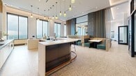 Located in the heart of Atlanta's Midtown neighborhood, this expansive lounge spans a single floor and offers a thoughtfully designed social space with a refined yet welcoming atmosphere. The interior is anchored by polished terrazzo flooring that runs throughout, complemented by warm wood slat accent walls, dramatic dark marble feature panels, and floor-to-ceiling windows that frame sweeping views of the Atlanta skyline.

The bar area serves as a central gathering point, featuring a sleek curved island with a dark base, white countertop, and copper trim detail, surrounded by stylish bar seating. Clusters of amber glass pendant lights hang overhead, adding a warm, ambient glow. Adjacent dining booths upholstered in rich teal and patterned fabrics provide intimate seating options.

A dedicated lounge zone features bold patterned wingback chairs arranged around a flat-screen TV mounted on a striking marble accent wall, creating an inviting entertainment nook. The game room area includes a full-size billiards table, casual round tables with mint green chairs, and additional lounge seating. Glass-paneled partition walls and sliding doors connect the spaces fluidly, while private seating alcoves along the perimeter offer views of the city below, making this lounge an exceptional amenity space.