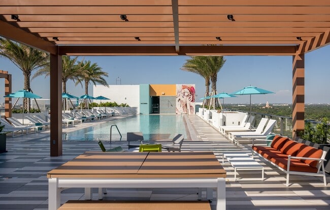 Indulge in the Miami sun on our expansive pool deck, offering luxury seating - Core At Link Apartments