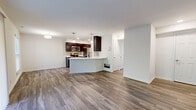This thoughtfully designed 2-bedroom, 2-bathroom single-story residence offers a practical and modern layout. The open-concept kitchen and living area serves as the heart of the home, featuring wood-look plank flooring, dark espresso cabinetry, stainless steel appliances, a subway tile backsplash, and a large peninsula with a white quartz countertop and undermount sink—illuminated by pendant lighting above. The living area extends toward a sliding glass door that opens to a green outdoor view, filling the space with natural light. Both bedrooms are carpeted and offer a quiet, comfortable retreat. The primary bedroom includes a well-organized walk-in closet with built-in shelving, drawers, and a wire storage rack. A second closet features wire shelving for additional storage. The two bathrooms each showcase marble-style tile. The first includes a tiled tub-shower combination with wood-look flooring, while the second features a frameless glass-door walk-in shower with floor-to-ceiling marble-style tile. A central hallway connects all rooms efficiently. Neutral white walls and consistent flooring choices throughout create a clean, cohesive aesthetic suited for comfortable everyday living.