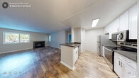 This 2-bedroom, 2-bathroom apartment at Shaliko Apartments in Rocklin, CA offers a well-designed single-story layout with a clean, modern aesthetic throughout. The open living area features rich wood-style flooring and neutral gray walls, creating a bright and welcoming atmosphere. A large window invites natural light and provides outdoor views, enhancing the sense of space. The kitchen is positioned adjacent to the living area with a pass-through counter, outfitted with white cabinetry, dark countertops, and a full suite of stainless steel appliances including a refrigerator, electric range, microwave, and dishwasher — all set on light wood-style flooring. Both bedrooms are carpeted and offer a calm, comfortable environment. One bedroom includes a sliding glass door with vertical blinds leading to an outdoor area. Each bedroom features a closet with built-in shelving for organized storage. The two bathrooms are finished with wood-style flooring, white vanity cabinetry, dark countertops, and large mirrors. One bathroom includes a shower/tub combo with a grab bar, while the other features contemporary vanity lighting. The overall ambiance is clean, functional, and move-in ready.