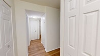 Located at 11637 Charter Oak Court in Reston, VA, this one-bedroom, one-bathroom residence offers a well-designed single-floor layout that makes efficient use of its space. The open-concept living and kitchen area serves as the heart of the home, where warm hardwood-style flooring flows throughout. The kitchen is a standout feature, boasting rich dark-espresso cabinetry that extends to the ceiling, granite countertops, a central island for additional prep and dining space, stainless steel appliances including a gas range, microwave, and refrigerator, and track lighting overhead. The living room is bright and airy, with sliding glass doors that open directly onto a private balcony overlooking lush, mature trees — bringing natural light and serene outdoor views into the space. The spacious bedroom is carpeted for comfort and includes a dedicated closet, while the bathroom features a clean, fully tiled soaking tub and shower combination. A hallway connects the rooms with added functionality. Neutral wall tones and clean finishes throughout lend the space a calm, move-in-ready aesthetic well-suited to everyday living in the heart of Reston.