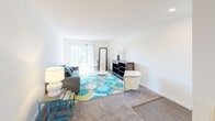 This single-floor, two-bedroom, one-bathroom unit at Clipper offers a well-organized layout designed for comfortable living. The living room is bright and generously proportioned, featuring sliding glass doors that invite abundant natural light and provide direct access to an outdoor patio. Neutral carpet and crisp white walls create a clean, versatile backdrop throughout.

The kitchen is thoughtfully updated with grey shaker-style cabinetry, dark granite countertops, a subway tile backsplash, and stainless steel appliances, including a refrigerator and dishwasher. A peninsula provides additional prep space and casual dining potential. Large-format tile flooring and recessed lighting complete the polished, functional aesthetic.

The two bedrooms are carpeted and finished with white walls, each featuring windows that allow natural light to filter in. A baseboard heating system provides comfortable climate control. The bathroom features a full tub-and-shower combination with classic white subway tile surround and chrome fixtures, maintaining a clean and timeless look. Overall, the unit presents a bright, neutral, and move-in-ready environment.
