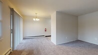 Located at 405 Franklin Tpke in Mahwah, NJ, this single-floor unit offers a functional and well-maintained layout suited for comfortable everyday living. The kitchen stands out with rich dark wood cabinetry, granite countertops, a classic subway tile backsplash, and stainless steel appliances including a gas range and refrigerator, all set on clean tile flooring. The open living and dining areas are finished with neutral-toned carpet and feature baseboard heating, an elegant chandelier, and a practical partial wall divider that defines the space without sacrificing openness. Natural light filters in through windows fitted with blinds, contributing to a bright and airy atmosphere throughout. A dedicated bedroom offers a generous layout with plush carpeting, a large window overlooking a green outdoor setting, and additional baseboard heating. The bathroom is clean and well-appointed, featuring a full soaking tub with a showerhead, a white vanity with ample storage, tile flooring, and a frosted window that brings in natural light while maintaining privacy. The entry area provides direct access to the outdoors and includes a wall-unit HVAC system alongside baseboard heating, ensuring year-round climate control. Overall, the space presents a clean, move-in-ready environment in a residential Mahwah location.