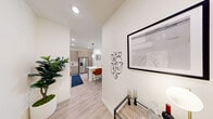 Located at 6741 Boulder Hwy in Las Vegas, NV, this well-appointed 2-bedroom, 2-bathroom unit offers a thoughtfully designed single-level layout. Light wood-style flooring flows throughout the space, complementing the clean, neutral palette that brightens every room. The entry hallway welcomes you with tasteful wall art and leads seamlessly into the open-concept living and kitchen area. The kitchen is a standout feature, showcasing contemporary flat-front cabinetry in a warm taupe finish, a full suite of stainless steel appliances including a French door refrigerator, microwave, range, and dishwasher, white subway tile backsplash, and a central island with seating — ideal for casual dining or entertaining. The living room is airy and inviting, benefiting from a large window and a sliding door that opens to a private outdoor area. Both bedrooms offer comfortable proportions with windows providing natural light, while the primary bedroom includes access to a dedicated bathroom with a glass-enclosed shower and a walk-in closet with dual hanging rods. A second full bathroom and two closets round out the functional layout. Recessed lighting throughout keeps the interior bright and modern.