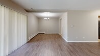 Located at 650 West Rand Road in Arlington Heights, Illinois, this single-floor residence offers 2 bedrooms and 2 bathrooms within a well-organized and functional floor plan. The open-concept living and dining area is a central highlight, featuring contemporary grey wood-look flooring, neutral toned walls, and a sliding glass door that floods the space with natural light and provides access to an outdoor balcony. A pendant light fixture anchors the dining area, which flows seamlessly into the living room.

The kitchen is equipped with rich dark cabinetry, light countertops, a stainless steel refrigerator, and a mosaic tile backsplash that adds a modern touch. Wood-look flooring continues throughout the kitchen and common areas for a cohesive aesthetic.

Both bedrooms are carpeted and offer generous closet space, including louvered bi-fold closet doors. The primary bedroom is notably spacious, with a large wall of closet storage and a window that brings in natural light. The second bedroom also features a window and built-in HVAC access overhead.

The two bathrooms include one with a glass-enclosed shower and another with a tiled tub surround. An in-unit laundry area adds everyday convenience, rounding out this practical and comfortable residence.