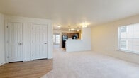 This single-floor residential unit offers a well-organized, functional layout designed for comfortable everyday living. The open-concept living area is generously sized, featuring soft, light-toned wall-to-wall carpeting and neutral walls that create a bright, welcoming atmosphere. A large window allows natural light to fill the space, while a peninsula counter seamlessly connects the living area to the kitchen.

The galley-style kitchen is a standout feature, outfitted with rich dark espresso cabinetry that extends to the upper walls, offering ample storage. Light-toned countertops and a double sink complement the black appliance suite, which includes a full-size refrigerator, range, and dishwasher. Durable wood-look flooring runs throughout the kitchen, and a window above the sink brings in additional natural light.

The bedrooms are carpeted and comfortably proportioned, with neutral walls and good natural light. The primary bedroom features dual closets, providing generous storage. The bathroom is finished with wood-look flooring, a dark vanity with a light countertop, and a full bathtub equipped with safety grab bars, catering to accessibility needs.

Throughout, the unit maintains a clean, neutral palette with consistent finishes, making it a versatile and move-in-ready space.