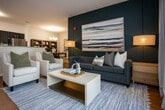 Located at 9449 Dayton Pike in Soddy Daisy, Tennessee, this single-floor residence offers a thoughtfully designed open-concept layout with modern finishes and a cohesive aesthetic throughout. Warm hardwood-style flooring flows seamlessly across the main living areas, tying the spaces together with a clean, contemporary feel.

The living room serves as a central gathering space, highlighted by a bold dark accent wall adorned with large-scale artwork, creating a striking focal point. The kitchen features dark espresso cabinetry, stainless steel appliances, and a granite-topped peninsula that provides both prep space and a casual seating area. Adjacent to the kitchen, a dedicated dining area is anchored by a rustic wood table beneath an elegant chandelier, with additional display storage nearby.

The primary bedroom is a serene retreat, accented by a deep-toned feature wall, natural light from a large window, and a ceiling fan overhead. A spacious walk-in closet with wrap-around wire shelving provides generous storage. A second bedroom offers a bright, comfortable space with its own ceiling fan and window access.

Two well-appointed bathrooms feature granite-topped vanities with dark cabinetry and tiled flooring. The in-unit laundry area adds everyday convenience. Throughout, the residence balances bold design choices with practical functionality, making it an inviting and well-organized home.