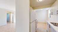 Located at 34 Dixington Crescent in Toronto's west end, this two-bedroom, one-bathroom unit offers a practical and comfortable layout across a single floor. Classic parquet flooring runs throughout the entire unit, lending warmth and a timeless character to every room. The spacious living room is bathed in natural light through large windows and features a balcony with views of the landscaped grounds and surrounding neighbourhood — an ideal spot for enjoying the outdoors. A decorative accent wall with a bold geometric design adds a modern touch to the living area. The primary bedroom is generously sized, featuring a dedicated window with tree-lined views, a baseboard heating unit, and ample closet storage with multiple built-in closets. The second bedroom is well-proportioned with its own window overlooking greenery and a ceiling light fixture. The bathroom is clean and functional, complete with a full soaker tub and shower combination with white tile surround. Throughout the unit, crisp white walls and clean trim contribute to a bright, airy atmosphere. The building itself is a classic brick mid-rise set among mature trees and green open space, offering a quiet residential setting within the city.