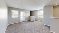 Located at 834 S Sheridan Drive in Muskegon, MI, this two-story, 1-bedroom, 1-bathroom home offers a thoughtfully organized layout spread across two levels. The entry level provides staircase access to the main living floor above, which houses the majority of the home's living space. The combined kitchen and living room area forms the heart of the home, featuring light hardwood-style flooring, white cabinetry with modern hardware, light countertops, and stainless and black appliances including a refrigerator, electric range, and dishwasher. An in-unit washer and dryer are also conveniently located within the kitchen area. Multiple windows allow natural light to brighten the open living space, which features neutral gray walls, plush carpeting, and a textured ceiling. The spacious bedroom is carpeted and bathed in natural light from a large window, and includes direct access to a dedicated walk-in closet with built-in shelving and hanging rods. The full bathroom is finished with wood-look flooring, a white vanity with clean countertops, and a full tub-shower combination with a curved curtain rod. Neutral gray tones throughout the home create a cohesive, move-in-ready aesthetic.