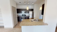 Located at 4099 Morriss Rd in Flower Mound, TX, this single-floor residence offers a well-designed layout with a cohesive blend of modern finishes and functional living spaces. The kitchen serves as a central highlight, featuring dark espresso cabinetry, granite countertops, and a full suite of stainless steel appliances including a refrigerator, electric range, and over-the-range microwave. A built-in wine rack adds a distinctive touch, while pendant lighting and track lighting illuminate the space effectively. The kitchen opens to the main living area via a breakfast bar with a double-basin sink, creating a connected, open feel. Arched doorways and five-panel interior doors contribute to the architectural character throughout. The bedrooms are carpeted and generously sized, each equipped with ceiling fans and windows fitted with blinds that allow ample natural light while maintaining privacy. Outdoor views of surrounding greenery are visible from several windows. The bathrooms feature wood-look tile flooring, dark vanity cabinetry with light countertops, soaking tubs with curved shower rods, and clean white tile surrounds. The overall design maintains a neutral, contemporary palette with light walls throughout, creating a bright and functional living environment.