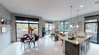 Located in the prestigious River Oaks corridor of Houston, TX, this contemporary single-floor residence showcases a thoughtfully designed open-concept layout with upscale finishes throughout. Large-format polished tile flooring runs seamlessly across the main living areas, reflecting abundant natural light that pours in through expansive black-framed windows and a sliding glass door leading to a private balcony with tree-lined views.

The kitchen is a standout feature, offering rich dark-stained cabinetry extending to the ceiling with a built-in wine rack, light granite countertops, stainless steel appliances, and a center island with bar seating — all flowing effortlessly into the open dining and living areas. The living room benefits from multiple windows on two sides, creating a bright and airy atmosphere.

The bedrooms are carpeted for comfort, with the primary suite featuring dedicated closet space and direct access to a well-appointed bathroom complete with a soaking tub, separate glass-enclosed shower, and granite vanity. A dedicated laundry room includes a washer and dryer, a utility sink with granite countertop, and dark wood overhead cabinetry. A clean hallway connects all private areas, completing this polished and functional Houston residence.