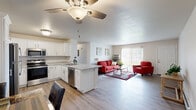 This thoughtfully designed single-floor residence offers a comfortable and functional layout across 1 bedroom, 2 bathrooms, an office, and a dedicated laundry room. The heart of the home is the open-concept kitchen and living area, where wood-look flooring, ceiling fans, and an abundance of natural light create a bright and welcoming atmosphere. The kitchen features crisp white cabinetry, light granite-style countertops, stainless steel appliances, and a peninsula with bar seating — ideal for casual dining or entertaining. The living room flows naturally from the kitchen and dining area, with a large sliding glass door that allows natural light to pour in and provides outdoor views. The carpeted bedroom is a comfortable retreat, featuring a ceiling fan, a closet with panel doors, baseboard heating, and a window overlooking the outdoors. The office provides a flexible, dedicated workspace. Two full bathrooms serve the residence, one of which includes a clean walk-in shower. The in-unit laundry room is equipped with a front-loading washer, ample wire shelving for storage, and hardwood-style flooring, adding everyday convenience. Throughout, the space maintains a clean, neutral palette with practical finishes that create a cohesive and inviting environment.