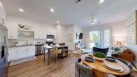Located at 515 Corso Lane in Davenport, Florida, this well-appointed two-story home offers three bedrooms, two bathrooms, and a thoughtful layout spread across two floors. The main level opens with a welcoming entryway hallway featuring warm wood-look flooring, built-in storage lockers, a woven bench, and wall-mounted hooks — a practical yet stylish mudroom-style entrance. This corridor leads directly into the bright, open-concept living, dining, and kitchen area. The kitchen is equipped with stainless steel appliances, white shaker cabinetry, a subway tile backsplash, and ample pantry storage. A central island provides additional prep and casual dining space. The living area benefits from natural light pouring through sliding glass doors that open to an outdoor view, complemented by a ceiling fan overhead. The upper floor houses all three bedrooms, including a spacious primary suite with a walk-in closet featuring wire shelving and a well-lit en-suite bathroom with dual vanities and a tiled shower. Bedrooms feature plush carpeting and windows that invite natural light. Two staircases connect the floors, and a dedicated laundry area and multiple closets add to the home's functionality. The attached garage completes this practical and comfortable residence.
