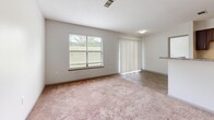 Located at 2420 Riverfront Drive in Little Rock, Arkansas, this one-bedroom, one-bathroom unit offers a practical and well-organized single-floor layout. The combined kitchen and living area forms the heart of the space, with wood-look flooring in the kitchen transitioning to soft carpeting in the living room. The kitchen is equipped with dark wood cabinetry, granite-style countertops, black appliances including a range and refrigerator, and a built-in dishwasher. A stacked washer and dryer unit is conveniently tucked into a dedicated nook within the kitchen area. The living room receives generous natural light through a large window and sliding glass door fitted with vertical blinds, creating a bright and welcoming atmosphere. The bedroom is a comfortably sized retreat, also carpeted, and features a window with outdoor views as well as a dedicated closet with built-in shelving for ample storage. An additional closet with shelving is accessible from the living area. The bathroom is clean and functional, featuring a full tub and shower combination with built-in shelving, wood-look tile flooring, and a vanity with storage. Neutral tones and simple finishes throughout give the space a clean, move-in-ready appeal.
