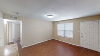 This single-floor unit offers a functional and cohesive layout across its living spaces. The living area serves as the central hub, featuring warm wood-style flooring, neutral beige walls, a textured ceiling, and a front-facing window fitted with blinds that allows natural light to filter in. A front entry door opens directly into this space, which also benefits from views into the kitchen area.

The kitchen is well-appointed with dark espresso cabinetry extending to the upper and lower sections, granite-style countertops, and a full suite of stainless steel appliances, including a refrigerator, electric range, over-the-range microwave, and dishwasher. A peninsula counter provides additional workspace and a natural transition to the living area.

The bedrooms are finished with plush carpeting, neutral walls, and ceiling fans with light fixtures. Each room includes a window with blinds, ensuring adequate natural light and ventilation.

The bathrooms feature wood-style flooring, dark vanity cabinetry with white countertops, and full tub-shower combinations with brushed nickel hardware, offering a clean and practical design throughout.