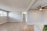 Located at 10555 W Jewell Ave in Lakewood, Colorado, this single-level 2-bedroom, 1-bathroom residence offers a clean, modern aesthetic throughout. Light wood-style flooring flows consistently across all rooms, complemented by soft gray walls, white trim, and textured ceilings that lend a cohesive, contemporary feel.

The open living area is spacious and bright, anchored by a ceiling fan and seamlessly connected to the kitchen. The kitchen is well-equipped with white shaker-style cabinetry, granite-look countertops, a tile backsplash, and stainless steel appliances, including a refrigerator, range, microwave, and dishwasher.

The generously sized primary bedroom features a ceiling fan, a closet, and ample room for furnishings. The second bedroom includes a large window overlooking greenery, a baseboard heater, and a wall-mounted air conditioning unit. Both bedrooms are bright and comfortable. The full bathroom is clean and functional, offering a tub/shower combination with tile surround and granite-look countertop detail.

Throughout the home, baseboard heating provides reliable warmth, and each room benefits from natural light via well-placed windows. The thoughtful layout makes efficient use of the available space, offering comfortable, move-in-ready living in a convenient Lakewood location.