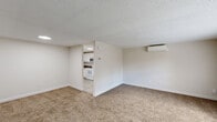 This two-bedroom, one-bathroom residence in Milford, Connecticut offers a practical and well-organized single-floor layout. The living room is a spacious, carpeted area bathed in natural light from large windows, featuring a wall-mounted mini-split air conditioning unit for year-round comfort and a textured ceiling throughout. An open sightline connects the living area directly to the kitchen, which is outfitted with white shaker-style cabinetry, dark granite-look countertops, tile flooring, and a full suite of white appliances including a range, built-in microwave, dishwasher, and refrigerator. A window above the sink brings in additional natural light.

The primary bedroom is a generously sized, sun-filled room with plush carpeting, a wide triple-panel window, a wall-mounted mini-split unit, and an expansive built-in closet with bi-fold doors. The second bedroom is equally comfortable, with soft carpet and ample natural light. The bathroom features neutral stone-look tile flooring, white subway tile surrounds, a window for ventilation, a baseboard heater, and a safety grab bar. Two closets and a connecting hallway complete the efficient floor plan, making this a well-appointed and functional residence.