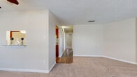 This single-floor, 2-bedroom, 1-bathroom home offers a practical and comfortable layout designed for everyday living. The spacious living room features soft carpeting, a ceiling fan, a textured ceiling, and a sliding glass door that brings in natural light and provides access to an outdoor area. A central hallway connects the living spaces to the private quarters, with durable hardwood-style flooring running through the kitchen and hallway areas.

The kitchen is efficiently designed with warm cherry wood cabinetry, granite-look countertops, a double stainless steel sink, and a distinctive mosaic tile backsplash that adds a decorative touch. The layout provides ample cabinet storage and counter workspace.

The primary bedroom is generously sized, featuring plush carpet, a ceiling fan, and a dedicated closet with built-in shelving. The second bedroom also offers carpeted flooring, a ceiling fan, and a bright window that allows natural light to flow in. A walk-in closet with dual shelving rods provides excellent storage capacity.

The full bathroom is well-finished with a wood-toned vanity, granite countertop, vessel sink, a framed mirror, and a tiled shower-tub combination. Wood-look tile flooring completes the bathroom's clean, cohesive aesthetic throughout this functional and inviting home.