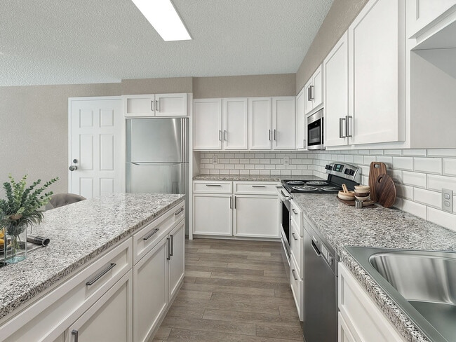 Cocina con encimeras de granito, electrodomésticos de acero inoxidable y gabinetes modernos. - Vetra Hurstbourne