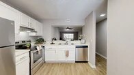 Located at 606 Park Ave in Orange Park, Florida, this single-floor, 2-bedroom, 2-bathroom residence offers a clean, modern aesthetic with a thoughtfully designed layout. Wood-look laminate flooring runs throughout the entire space, complemented by neutral gray walls and crisp white trim, creating a cohesive and contemporary feel.

The kitchen is a standout feature, boasting white shaker-style cabinetry, light stone-look countertops, a classic subway tile backsplash, and a full suite of stainless steel appliances including a range, dishwasher, and refrigerator. The kitchen opens directly to the living area via a pass-through counter, enhancing the sense of openness and flow. A ceiling fan anchors the living room, which offers generous space for a variety of furniture arrangements.

Both bedrooms are comfortably sized, with the primary bedroom offering ample room and access to a well-organized walk-in closet featuring built-in shelving and dual hanging rods. Natural light filters in through window blinds in the bedrooms. Each bathroom is finished with wood-look flooring, a tub-shower combination, and clean white fixtures. A hallway connects the living areas to the private quarters, and a louvered-door closet near the kitchen provides additional storage.
