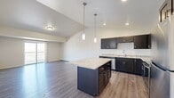 Located at 4800 46th St S in Fargo, North Dakota, this one-bedroom, one-bathroom unit offers a thoughtfully designed layout across a single floor. The open-concept kitchen and living area serves as the heart of the home, showcasing dark shaker-style cabinetry, light granite countertops, stainless steel appliances — including a range, microwave, dishwasher, and refrigerator — and a center island with pendant lighting overhead. Recessed lighting and warm luxury vinyl plank flooring complete the kitchen's polished, contemporary feel. The living room extends naturally from the kitchen and opens to a private balcony through sliding glass doors, filling the space with natural light and outdoor views. Baseboard heating runs along the walls, ensuring comfort throughout the seasons. The bedroom is a quiet retreat featuring plush carpet, a large window with outdoor views, and access to a generously sized walk-in closet outfitted with wire shelving on multiple walls for ample storage. The bathroom includes a full tub-shower combination with clean white surrounds and vinyl plank flooring that mirrors the rest of the unit. A dedicated entrance completes the functional and well-organized floor plan.