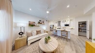 Located in Las Vegas, NV, this well-appointed 2-bedroom, 2-bathroom home offers a thoughtfully designed single-level layout with a clean, contemporary aesthetic throughout. The open-concept living and kitchen area serves as the heart of the home, where light wood-style flooring, recessed lighting, and a ceiling fan create a bright and airy atmosphere. The living room flows seamlessly into the kitchen, which features white shaker cabinetry with glass-front upper panels, a subway tile backsplash, stainless steel appliances including a range with a sleek hood vent and a French door refrigerator, and a central island with bar seating — ideal for both cooking and casual dining. Natural light filters in through windows dressed with soft curtains and blinds, enhancing the home's warm, neutral palette. The primary bedroom is generously sized and includes a walk-in closet with built-in shelving. The second bedroom is bright and versatile, with natural light and its own closet access. Both bathrooms are finished with light tile flooring; one features a tub-shower combination with a rainfall showerhead. A dedicated in-unit laundry room houses a full-size washer and dryer. The hallway connects all spaces efficiently, completing this functional and stylish home.