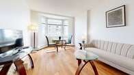 Located at 160 Chapel St in Ottawa's Sandy Hill neighbourhood, this one-bedroom, one-bathroom unit offers a compact yet well-organized layout across a single floor. Warm hardwood flooring flows throughout the main living areas, lending a cohesive and inviting feel to the space.

The living room is a standout area, characterized by a large multi-panel window that frames views of the surrounding urban streetscape and draws in generous natural light, creating an airy, open atmosphere. The space comfortably accommodates both a seating area and a dining nook.

The kitchen is efficiently designed with white cabinetry extending to the upper walls, white appliances including a stove and refrigerator, and light countertops. A countertop peninsula provides additional prep space and a natural transition into the living area.

The bedroom is a comfortable, well-proportioned room featuring a window that continues the theme of natural light throughout the unit. A built-in double closet offers practical storage, and hardwood flooring extends into this room as well.

The bathroom is finished in a clean, classic style with white tile flooring, a vanity with under-sink storage, a lighted mirror above the sink, and a separate medicine cabinet, keeping the space bright and functional throughout.