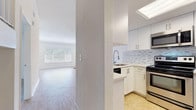 This two-story residence offers a clean, modern aesthetic defined by crisp white walls, light wood-style flooring, and an abundance of natural light throughout. The main level centers on a generous open living area with soaring ceilings, a sliding glass door that invites outdoor light, and a track-lit entryway that adds a contemporary touch. A pass-through kitchen counter connects the living space to a well-appointed kitchen, which features white shaker-style cabinetry, light quartz countertops, a mosaic tile backsplash, and a full suite of stainless steel appliances including a range, over-the-range microwave, and dishwasher. A skylight overhead floods the kitchen with natural light, enhancing its bright, functional design. A staircase with wood-toned railing leads to the upper level, where additional rooms continue the home's consistent palette of white walls and light hardwood-style flooring. The upper floor includes generously sized rooms bathed in natural light from large windows, with vaulted ceilings that add dimension and airiness. A well-finished bathroom on the upper level features a white vanity with quartz countertop and modern brushed nickel fixtures. Throughout the home, a cohesive design language of neutral tones and clean finishes creates a versatile, move-in ready environment.