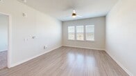 This compact yet well-designed 710 square foot residence offers a harmonious blend of functionality and style. The single-story layout comprises one bedroom, one bathroom, and an open-concept living area. The modern kitchen is a standout feature, boasting white cabinetry, granite countertops, and stainless steel appliances, including a refrigerator, oven, and microwave. A central island provides additional preparation space and casual dining options.

The living room flows seamlessly from the kitchen, creating an open and airy atmosphere. Large windows allow natural light to flood the space, while ceiling fans ensure comfortable air circulation. The bedroom, measuring 200 square feet, offers ample space and is equipped with a ceiling fan and windows for a bright, airy feel. Plush carpeting in the bedroom contrasts with the sleek wood-look flooring found throughout the main living areas.

The bathroom features modern fixtures, including a combined tub and shower with stylish tile work. A dedicated closet space provides valuable storage options. Throughout the home, recessed lighting and neutral wall colors contribute to a clean, contemporary aesthetic. This efficiently designed property maximizes every square foot, creating a comfortable and inviting living space ideal for singles or couples.