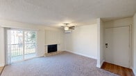 Located at 4835 N Cedar Ave in Fresno, CA, this 2-bedroom, 1-bathroom residence offers a well-organized single-floor layout designed for comfortable everyday living. The living room serves as the heart of the home, featuring plush carpeting, a ceiling fan with light fixture, a wall-mounted mini-split AC unit, and a classic fireplace framed by a white shiplap surround. Sliding glass doors open directly to a private balcony, filling the space with natural light. The adjoining dining area transitions seamlessly into the galley-style kitchen, which is equipped with granite-look countertops, warm wood cabinetry, a double sink, white appliances, and durable hardwood-style flooring. The primary bedroom is generously sized, offering carpet flooring, a ceiling fan, a mini-split AC unit, and a large sliding-door closet. The second bedroom also features carpet, a mini-split unit, and a window with outdoor views. The full bathroom includes a granite-topped vanity with wood cabinetry and an ornate framed mirror. Additional highlights include four closets, a utility room, and a hallway connecting all areas. The textured ceilings and neutral color palette create a cohesive, move-in-ready atmosphere throughout.