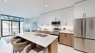 Located at 30 Queensland Rd in Stratford, Ontario, this well-appointed one-bedroom, one-bathroom unit offers a thoughtfully designed layout with modern finishes throughout. The open-concept kitchen is a standout feature, showcasing two-tone cabinetry — warm wood lowers paired with crisp white uppers — complemented by quartz countertops, a large island with an undermount sink, stainless steel appliances, and a subtle tile backsplash. Light-toned hardwood flooring runs throughout, enhancing the bright and airy atmosphere created by recessed lighting and large floor-to-ceiling windows. The living room benefits from an abundance of natural light through expansive black-framed windows, offering views of the surrounding neighbourhood and access to a private balcony. The generously sized primary bedroom features built-in wardrobe storage, recessed lighting, and a large window that brings in ample daylight. The full bathroom is finished with clean white subway tile surrounding the tub-shower combination, neutral floor tile, a wood-accented vanity, and a crisp white countertop. Throughout the unit, a neutral colour palette and contemporary design elements create a cohesive, modern aesthetic suited to comfortable everyday living.