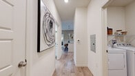 Located at 120 Parkway Dr in Jackson, MS, this single-floor, 2-bedroom, 3-bathroom home offers a clean, modern aesthetic throughout. Light wood-look flooring flows seamlessly from the entry hallway — adorned with wall art and a contemporary feel — through the main living areas. The bright living room features large windows with French doors that invite natural light, complemented by a ceiling fan and warm, neutral tones. The kitchen is well-equipped with white cabinetry, light granite-style countertops, a subway tile backsplash, and stainless steel fixtures, providing ample storage and prep space. The spacious primary bedroom includes plush carpeting, a bold navy accent wall, and a generously sized walk-in closet with built-in wire shelving. The bathrooms are finished with large-format tile surrounds, including a soaking tub. A dedicated laundry room with full-size washer and dryer hookups adds everyday convenience. Two closets provide additional storage throughout. The home's cohesive design, practical layout, and quality finishes make it a comfortable and functional living space.