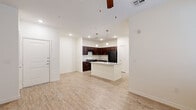 This efficiently designed 1-bedroom, 1-bathroom residence offers a thoughtful single-floor layout that maximizes comfort and functionality. The open-concept kitchen and living area forms the heart of the home, featuring light wood-look flooring that flows throughout the main living spaces. The kitchen is well-equipped with rich dark espresso cabinetry, granite-look countertops, a kitchen island with a double sink, and black appliances including a refrigerator, range, and dishwasher. Pendant lighting above the island adds a stylish touch, while recessed lighting ensures the space is well-lit. The living area benefits from natural light through large windows fitted with blinds and features a ceiling fan for added comfort. A glass-paneled exterior door provides additional brightness. The bedroom offers plush carpeting, a ceiling fan, and a generous closet with built-in shelving. Large windows invite ample natural light into the room. The bathroom is spacious and elongated, showcasing dark cabinetry, a wide vanity with dual mirrors, light countertops, and a separate shower and tub area. Light wood-look flooring continues throughout the bathroom, completing the cohesive aesthetic of this clean, modern residence.