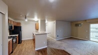 Located in Spokane, WA, this well-appointed 3-bedroom, 2-bathroom residence offers a practical and comfortable single-floor layout. The open-concept heart of the home seamlessly connects the kitchen, dining, and living areas, creating a versatile space ideal for both daily living and entertaining. The kitchen is outfitted with warm wood cabinetry, black appliances including a range, microwave, refrigerator, and dishwasher, complemented by light countertops and hardwood-style flooring. Track lighting adds a functional, modern touch overhead. The expansive living area transitions to soft carpeting, providing a comfortable and inviting atmosphere, and opens to a private balcony. The generously sized primary bedroom offers a peaceful retreat, while the two additional bedrooms feature carpeted floors, natural light from windows, and baseboard heating. Two full bathrooms include wood-toned vanities with ample counter space and tub/shower combinations. A dedicated in-unit laundry room houses side-by-side washer and dryer units with overhead shelving for added convenience. Four closets distributed throughout ensure plentiful storage. Neutral wall tones and clean white trim create a cohesive, move-in-ready aesthetic throughout the entire residence.