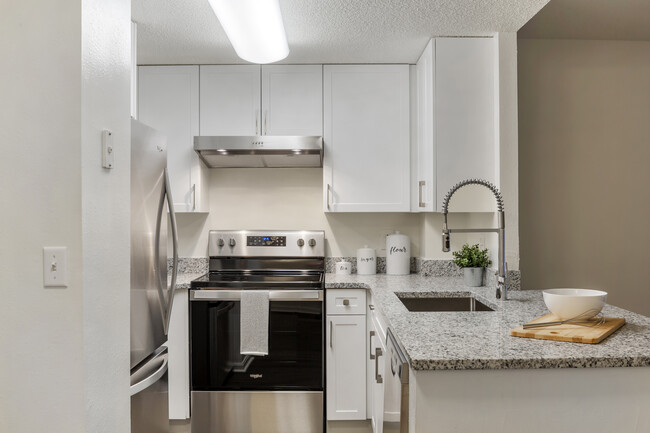 Cocina renovada del Paquete II con gabinetes blancos, encimeras de cuarzo, electrodomésticos de acero inoxidable y pisos de superficie dura - eaves Quincy