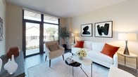 Located at 4901 Montgomery Lane in the heart of Bethesda, Maryland, Unit 205 is a thoughtfully designed residence that combines modern aesthetics with functional living. The open-concept main living area seamlessly connects the kitchen, dining, and living spaces, creating a bright and cohesive environment. Dark hardwood flooring runs throughout, grounding the space with warmth and sophistication.

The contemporary kitchen is outfitted with light wood cabinetry, a crisp white quartz countertop, a subway tile backsplash with under-cabinet lighting, and a full suite of stainless steel appliances. A central island with seating provides both additional prep space and a natural gathering spot for casual dining.

The living area features floor-to-ceiling windows and a glass sliding door that opens onto a private balcony, flooding the room with natural light and offering pleasant outdoor views of the surrounding Bethesda neighborhood.

The bedroom is a serene retreat, featuring large windows with roller shades, dark hardwood floors, and a calm, neutral palette. The bathroom is finished with tile flooring, a soaking tub with shower, and a wood-framed vanity mirror with quartz countertops.

Residents also enjoy access to a spacious shared outdoor terrace with modern lounge seating and dining areas, ideal for relaxing or entertaining outdoors.