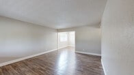 This single-story, 2-bedroom, 2-bathroom residence in Merced, California offers a clean, modern aesthetic throughout its thoughtfully arranged floor plan. The combined living and dining area is a welcoming centerpiece, featuring rich wood-look flooring, neutral gray walls, and a textured ceiling. A large window floods the space with natural light and offers views of the surrounding greenery, while an adjacent dining nook is accented by a classic chandelier.

The kitchen is well-equipped with gray shaker-style cabinetry, granite-look countertops, a white subway tile backsplash, and matching white appliances including a dishwasher and range. Wood-look flooring continues throughout this space, tying together the home's cohesive design.

Both bedrooms are carpeted for comfort and each includes a closet with built-in shelving. The primary bedroom is generously sized and benefits from a ceiling fan. The second bedroom is equally comfortable, also featuring a ceiling fan and its own closet.

The two bathrooms are finished with granite-look countertops, dark gray cabinetry, and wood-look flooring. One bathroom features a walk-in glass shower, while the other offers a full tub-shower combination with white tile surround. A hallway connects the private quarters, and four closets throughout the home provide ample storage.