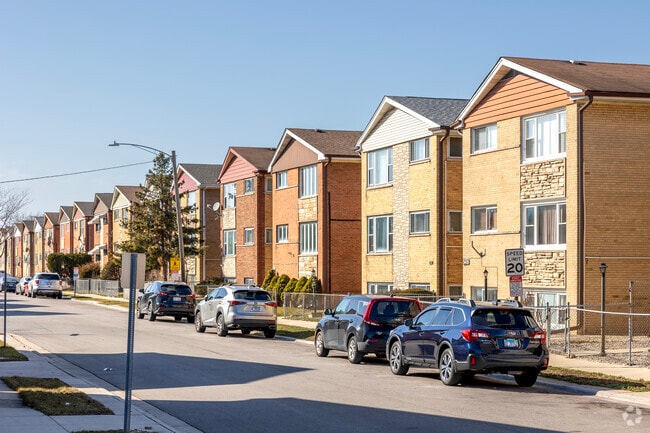 Tall multi-family houses line the northern border of Schiller Park.