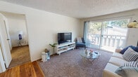This single-floor unit at 2323 58th Ave E in Fife, Washington offers a well-organized layout designed for comfortable everyday living. The living room serves as the central gathering space, featuring plush carpeting, neutral walls, and a textured ceiling. A large sliding glass door fills the room with natural light and opens directly onto a private balcony, providing pleasant outdoor views of the surrounding neighborhood and mature trees.

The kitchen is efficiently designed with white cabinetry, speckled laminate countertops on both sides, and warm hardwood-style flooring that extends throughout the non-carpeted areas of the unit. Adjacent to the kitchen, the dining area accommodates a small table and chairs and includes a built-in closet with sliding doors for added storage convenience.

The bedroom is a comfortable retreat, carpeted and well-lit by a window with outdoor views. It connects to a dedicated walk-in closet, providing ample storage space. The bathroom features hardwood-style flooring, a single vanity with a wood-framed mirror, and a full tub-shower combination. Throughout the unit, a consistent neutral color palette and clean finishes contribute to a bright, tidy ambiance suited to a range of lifestyles.