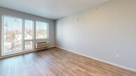 Located at 650 Aguirre Street in Saint Paul, Minnesota, this single-floor unit offers a well-designed, efficiently organized layout that combines the living room, dining area, and kitchen into one open space. The living area features warm wood-look laminate flooring throughout, neutral gray walls, and a wall-mounted HVAC unit beneath a large window that invites natural light and offers views of the surrounding neighborhood.

The kitchen is outfitted with rich dark-wood cabinetry—both upper and lower—paired with light countertops and a full suite of stainless steel appliances, including a refrigerator, electric range, over-the-range microwave, and dishwasher. A built-in countertop extension provides a convenient dining or workspace area, and an additional window brings in ample natural light.

The bathroom features a wide vanity with dark wood cabinetry and a white countertop, a large mirror, grab bars for accessibility, and a stacked in-unit washer and dryer—adding exceptional convenience to everyday living.

A dedicated closet provides practical storage within the compact footprint. Recessed lighting and clean, modern finishes throughout give this unit a bright, contemporary feel, making it a functional and comfortable space in the heart of Saint Paul.