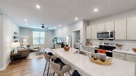 Located in Stuart, FL, this well-appointed 2-bedroom, 2-bathroom residence offers a thoughtfully designed single-floor layout that maximizes comfort and functionality. The open-concept kitchen and living area serves as the heart of the home, anchored by a large granite-topped island with bar seating — ideal for casual dining or entertaining. The kitchen features light shaker-style cabinetry, a white subway tile backsplash, stainless steel appliances, and recessed lighting throughout. Wood-style plank flooring flows seamlessly across the main living areas, adding warmth and cohesion to the space. The living room is bright and airy, with a ceiling fan, large windows with blinds, and neutral gray walls that create a calm, modern ambiance. The primary bedroom offers a comfortable retreat with a walk-in closet and an en-suite bathroom finished with granite countertops and a glass-enclosed shower. The second bedroom is equally well-sized, featuring natural light from a large window and a ceiling fan. The second bathroom includes a granite vanity and a full tub-shower combination. Hallways connect the rooms efficiently, and a dedicated closet provides additional storage. The overall design palette — soft grays, warm wood tones, and clean white accents — creates a cohesive and contemporary living environment.