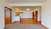 Located at 5317 South Palouse in Spokane, WA, unit G252 is a thoughtfully laid-out single-floor residence that balances comfort and functionality. The entryway opens into a hallway with warm hardwood-style flooring that flows throughout the main living areas, creating a cohesive and inviting atmosphere. The open-concept living and dining area transitions between hardwood-style flooring and plush carpet, offering a comfortable space anchored by a large window that allows natural light to fill the room. The galley-style kitchen is efficiently designed with warm honey-toned wood cabinetry, tile backsplash, a full suite of white appliances including a refrigerator, electric range, microwave, and dishwasher, along with ample counter and storage space. A breakfast bar connects the kitchen to the main living area. Two well-proportioned bedrooms each feature plush carpeting, natural light from large windows with blinds, and baseboard heating. Two full bathrooms serve the unit, each equipped with a tub/shower combination, a wood-vanity with countertop storage, and clean, neutral finishes — one with hardwood-style flooring and one with tile flooring. A dedicated laundry area with washer and dryer hookups adds further convenience to this functional and comfortable Spokane residence.
