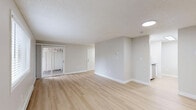Located at 4601 East 18th Street in Vancouver, WA, this two-bedroom, one-bathroom unit offers a thoughtfully organized single-floor layout. Light wood flooring runs throughout the entire space, complementing neutral gray walls and crisp white trim to create a clean, contemporary aesthetic. Textured ceilings add a classic touch across all rooms.

The open-concept living and kitchen area is bright and inviting, with natural light flowing in through large windows and a sliding glass door. Baseboard heating units run along the walls, ensuring year-round comfort. The kitchen is well-appointed with white shaker cabinetry, gray countertops, a white tile backsplash, and stainless steel appliances including a range and dishwasher.

Both bedrooms are comfortably sized, with the primary bedroom offering a generous footprint and a dedicated closet. The second bedroom connects easily to the main hallway. In total, the unit features four closets, providing ample storage throughout. The bathroom includes a wide vanity with white cabinetry, gray countertops, a large mirror, and modern light fixtures. A dedicated utility closet houses the water heater. The surrounding landscape, visible from the windows, includes mature trees that enhance the sense of a peaceful residential setting.