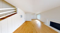 Located at 49 Northgate Ave in Daly City, CA, this two-bedroom, one-bathroom two-story home offers a well-organized layout spread evenly across two floors. The main level features a bright, open living room with warm hardwood flooring, vertical blinds framing large windows, a ceiling fan, and a classic white fireplace that serves as a focal point. Natural light pours in generously, creating an airy and welcoming atmosphere. A staircase with white railings connects the floors, adding a clean architectural touch. The kitchen is thoughtfully appointed with white shaker-style cabinetry, granite countertops, stainless steel appliances including a range and refrigerator, and rich hardwood flooring. The full bathroom presents a clean, bright aesthetic with a tub-shower combination, a white vanity, and hardwood flooring. Upstairs, two carpeted bedrooms provide comfortable retreats. The primary bedroom is generously sized, featuring a wide mirrored sliding closet door and a large window with outdoor views of the surrounding neighborhood. The second bedroom is equally well-lit and carpeted. A hallway and dedicated closet space complete the upper level, ensuring practical storage throughout this efficiently designed home.